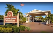 Front entrance of Life Care Center of Melbourne with sign and flag.