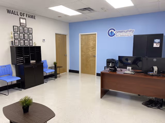 Reception area with desks, blue chairs, and a wall of fame at Community Home Health Care.