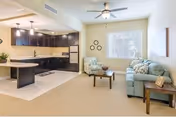 Open-concept senior living area featuring a kitchen island and light blue sofas.