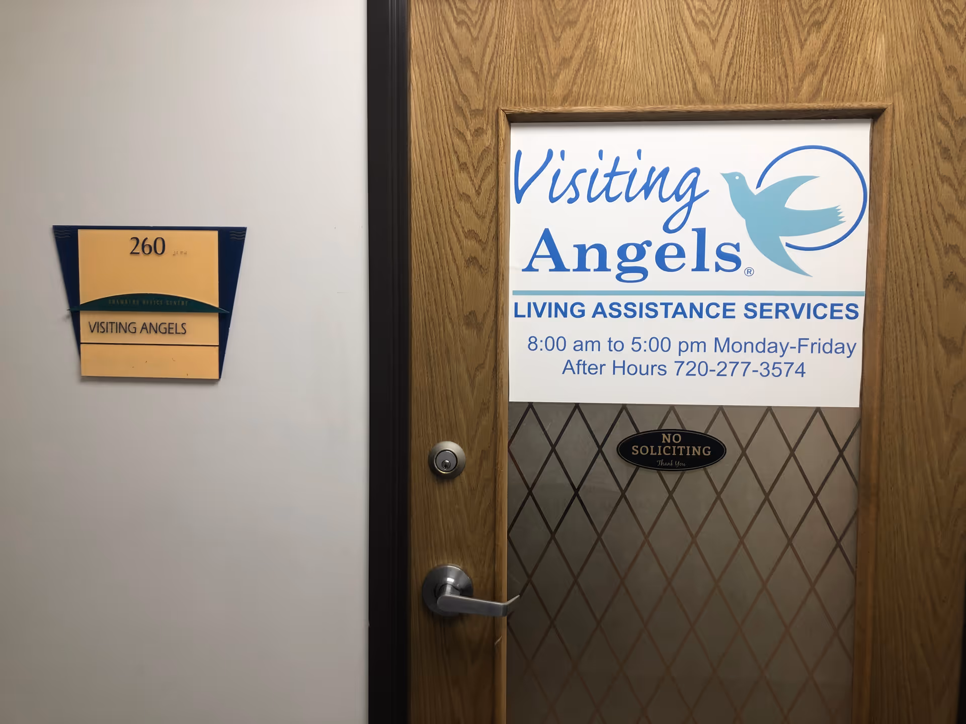 Door in hallway displaying Visiting Angels sign and room number plaque.