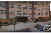 Exterior view of Park Terrace Care Center Inc building showing entrance and parked car.