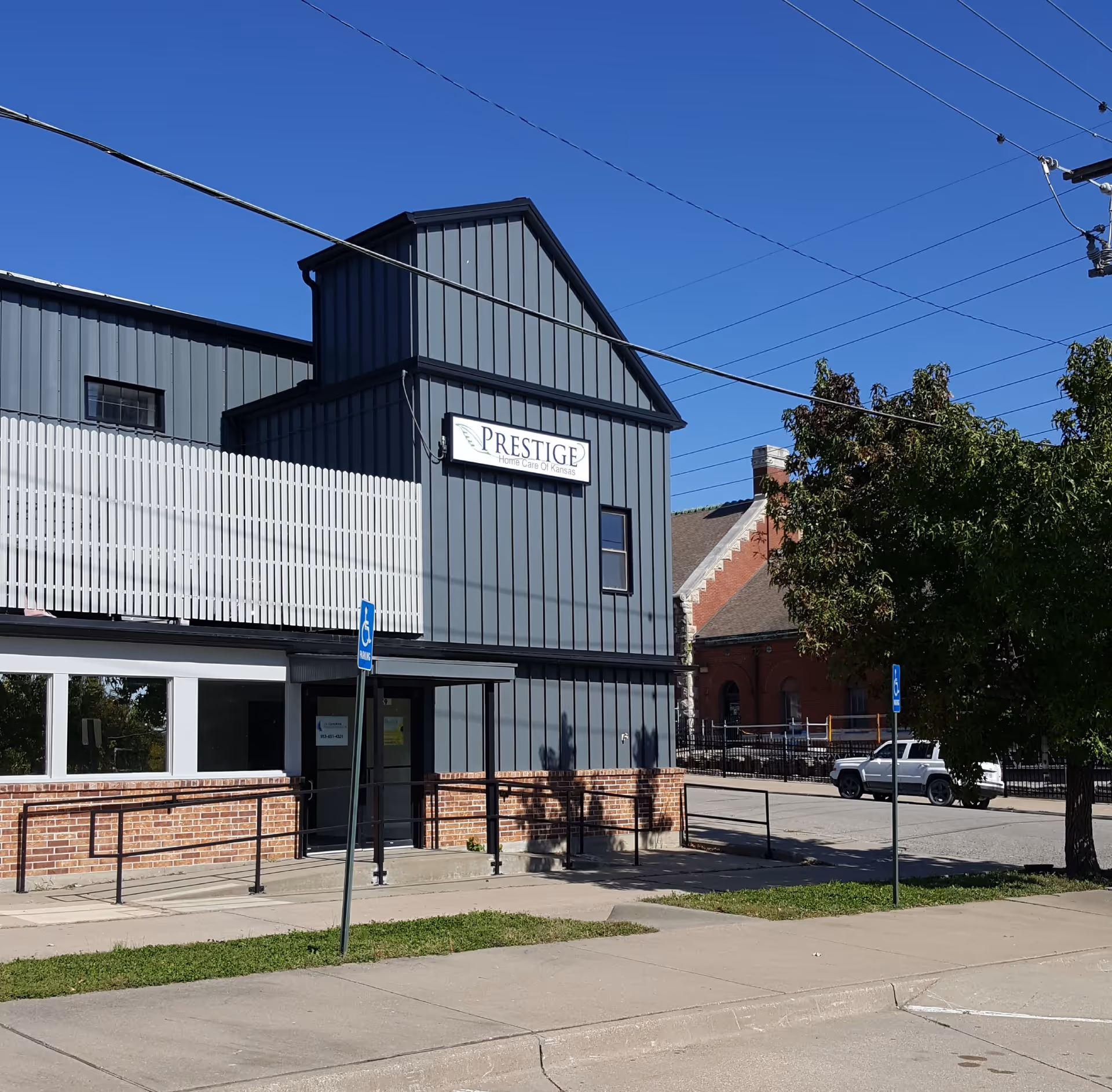 Exterior view of Prestige Home Care of Kansas building with sign and ramp