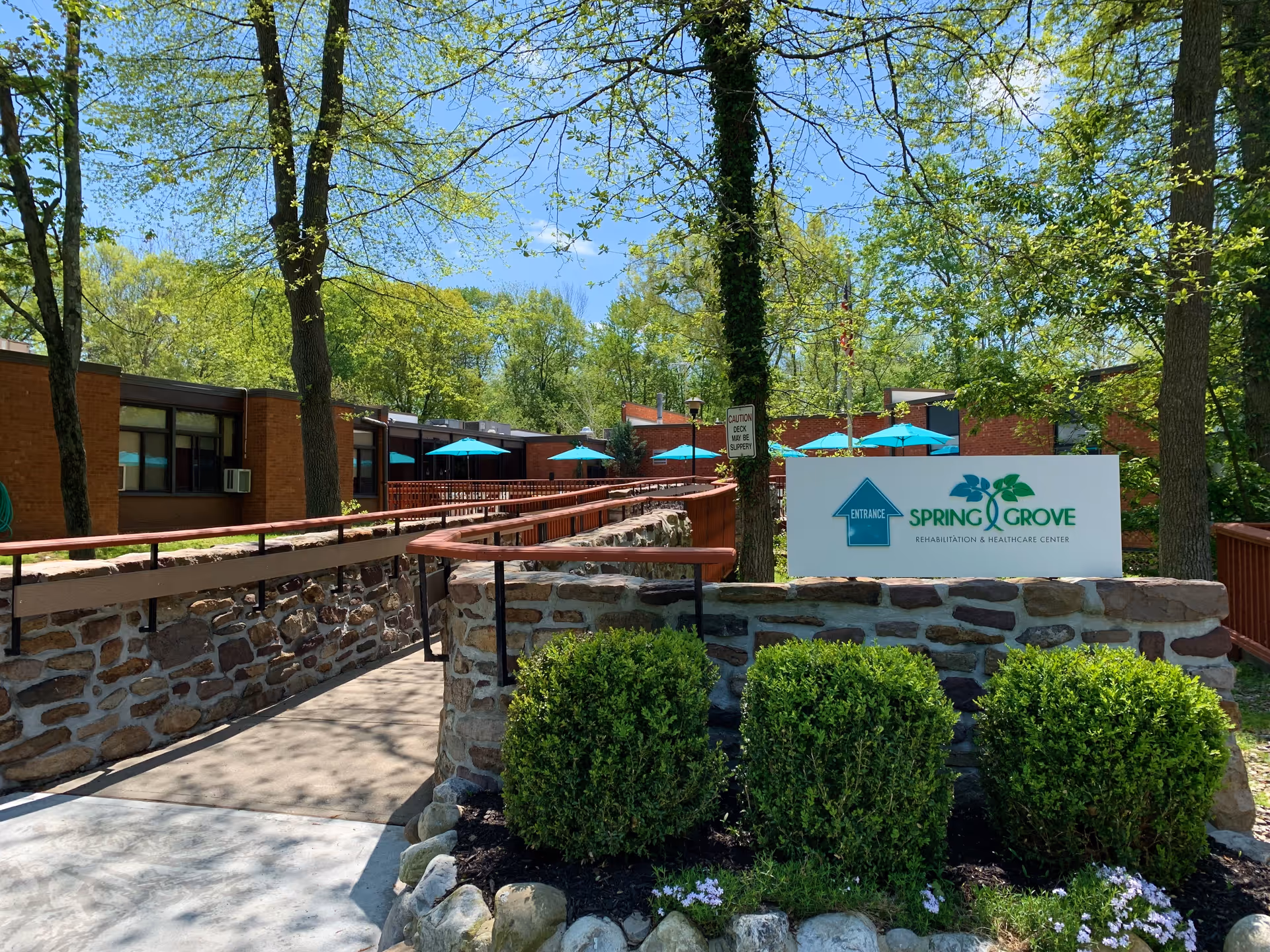 Exterior view of Spring Grove Rehabilitation and Healthcare Center with outdoor seating.