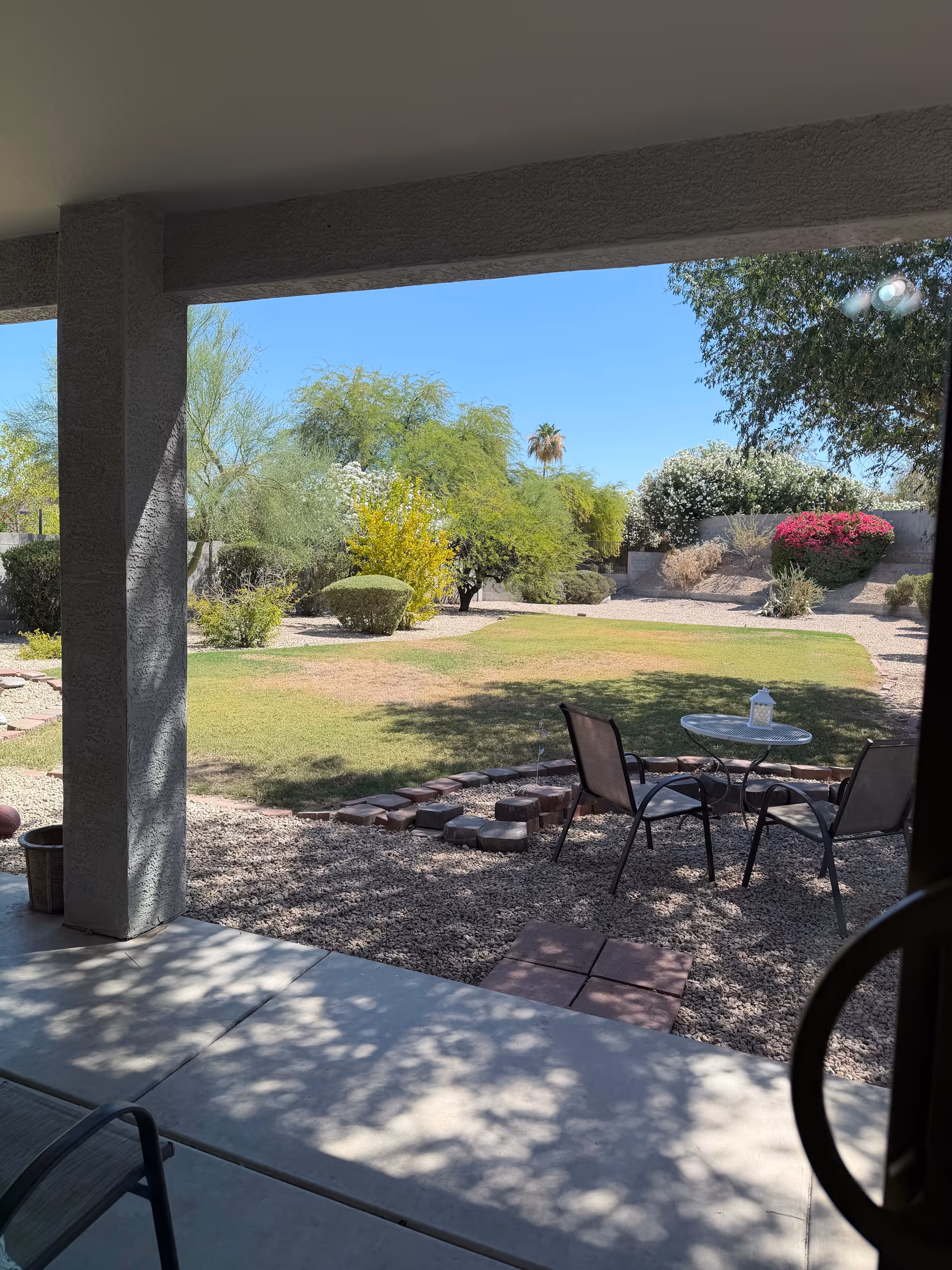 Outdoor covered patio at a senior living facility with a small table and chairs.