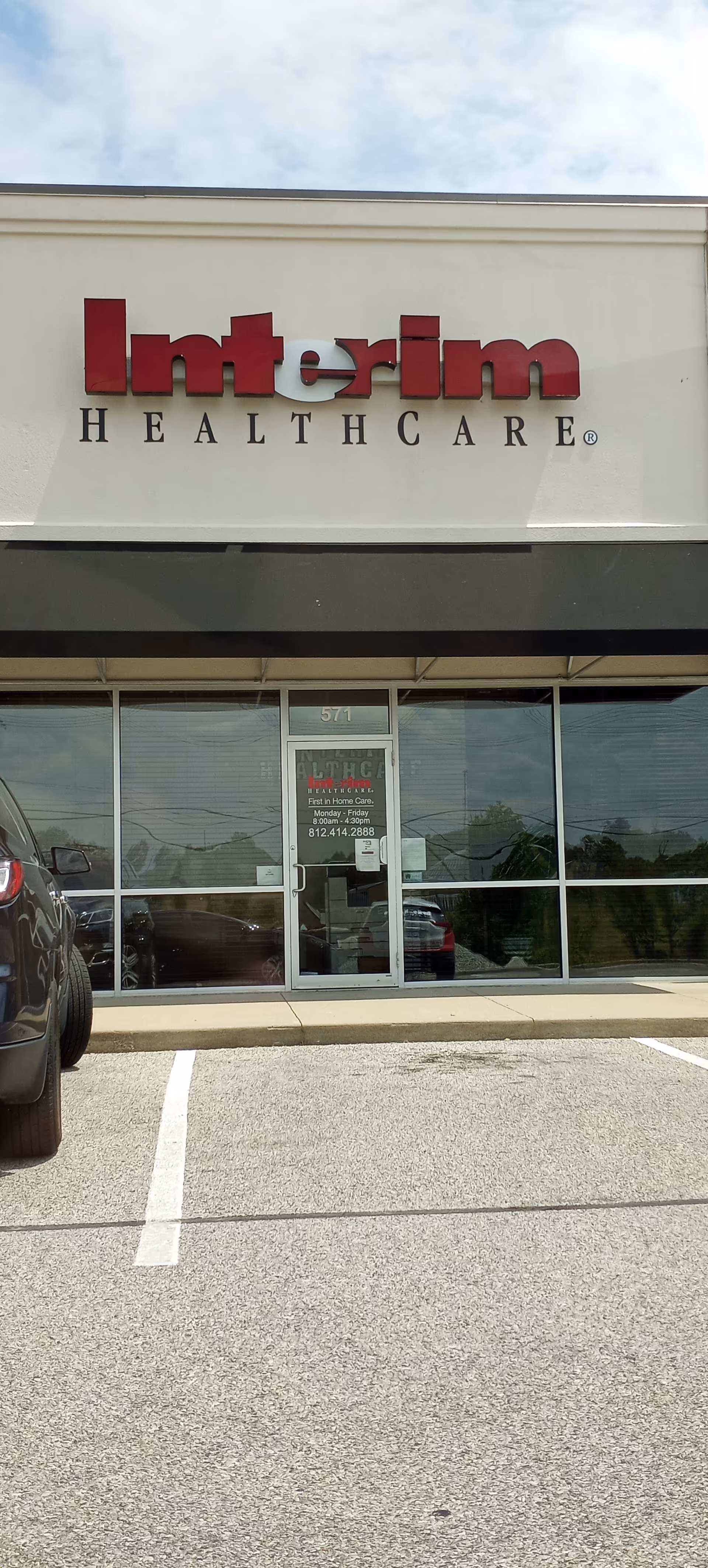 Exterior of Interim HealthCare of Scottsburg with a large red sign and glass entrance.