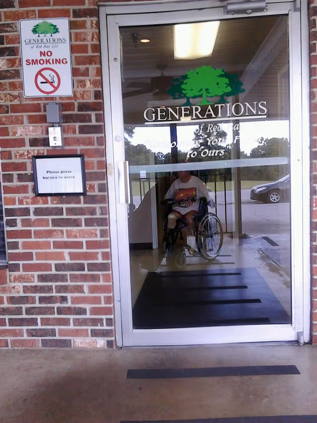Wheelchair user entering Generations facility through a glass door.