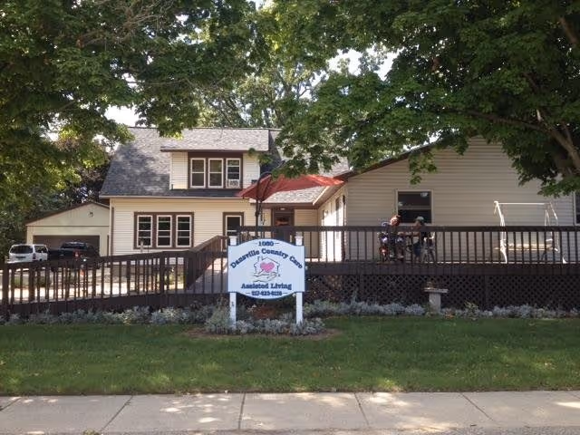 Exterior view of Dansville Country Care building with a sign and outdoor deck.