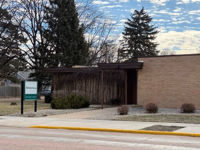 Exterior view of Avera@Home Hospice facility with sign and entrance pathway.