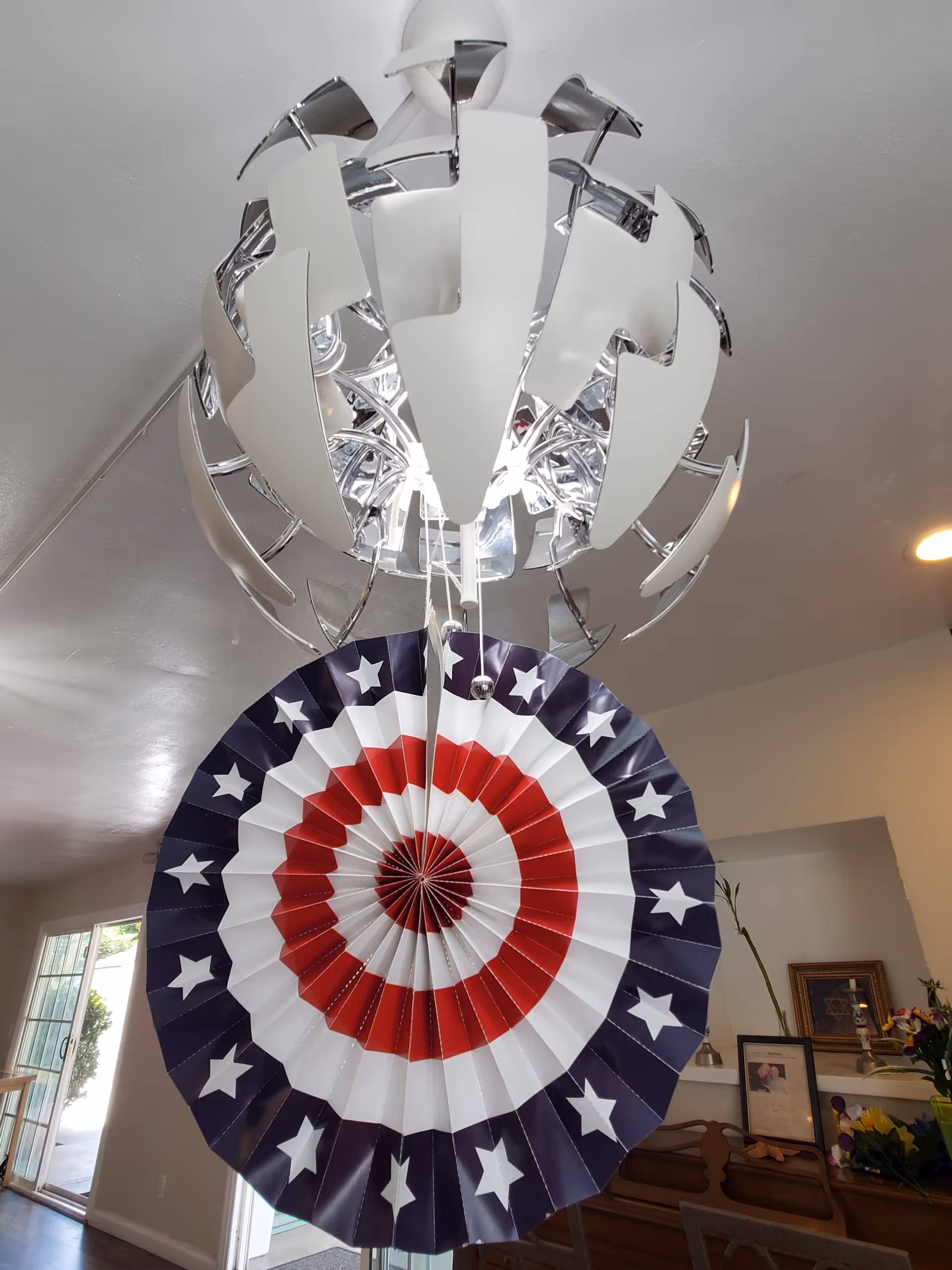 Interior dining area featuring a modern chandelier and large patriotic circular decoration.