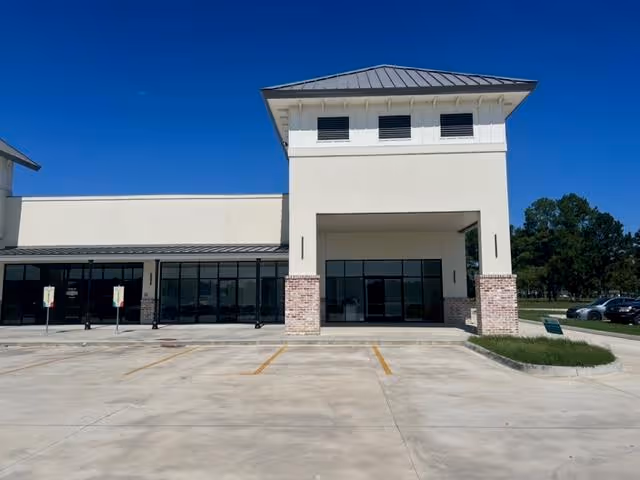 Front view of a modern senior care facility with a tall central tower and glass entrance.