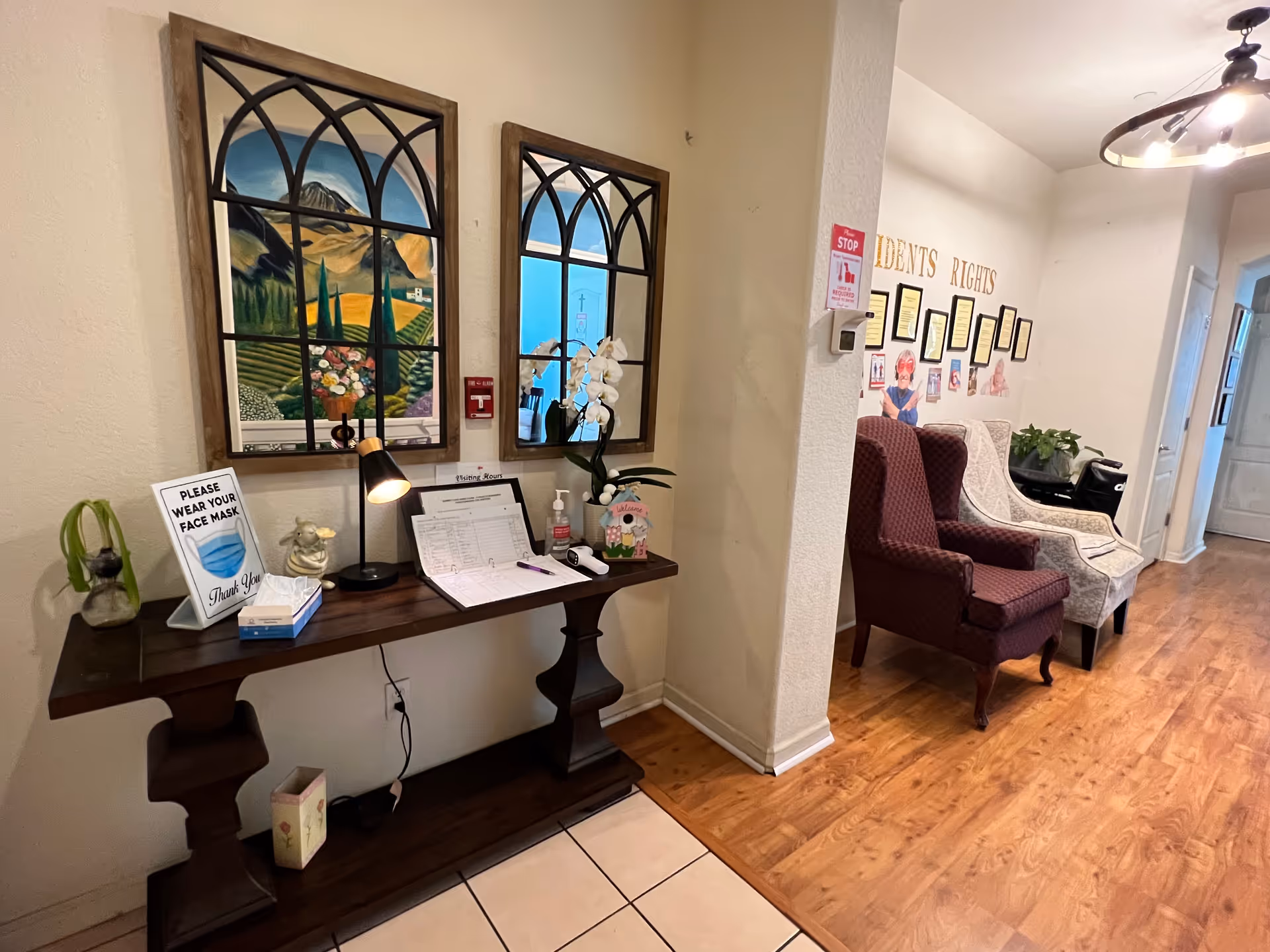 Hallway lobby at Simone Summit Care Home with a console table, arched art, and seating area.