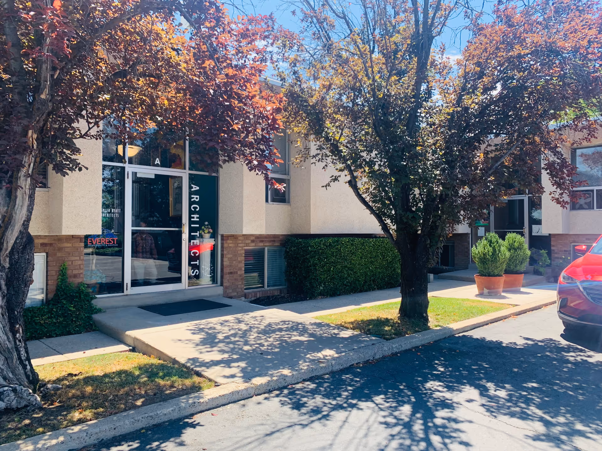 Exterior view of Everest Home Health and Hospice entrance with glass doors and trees.
