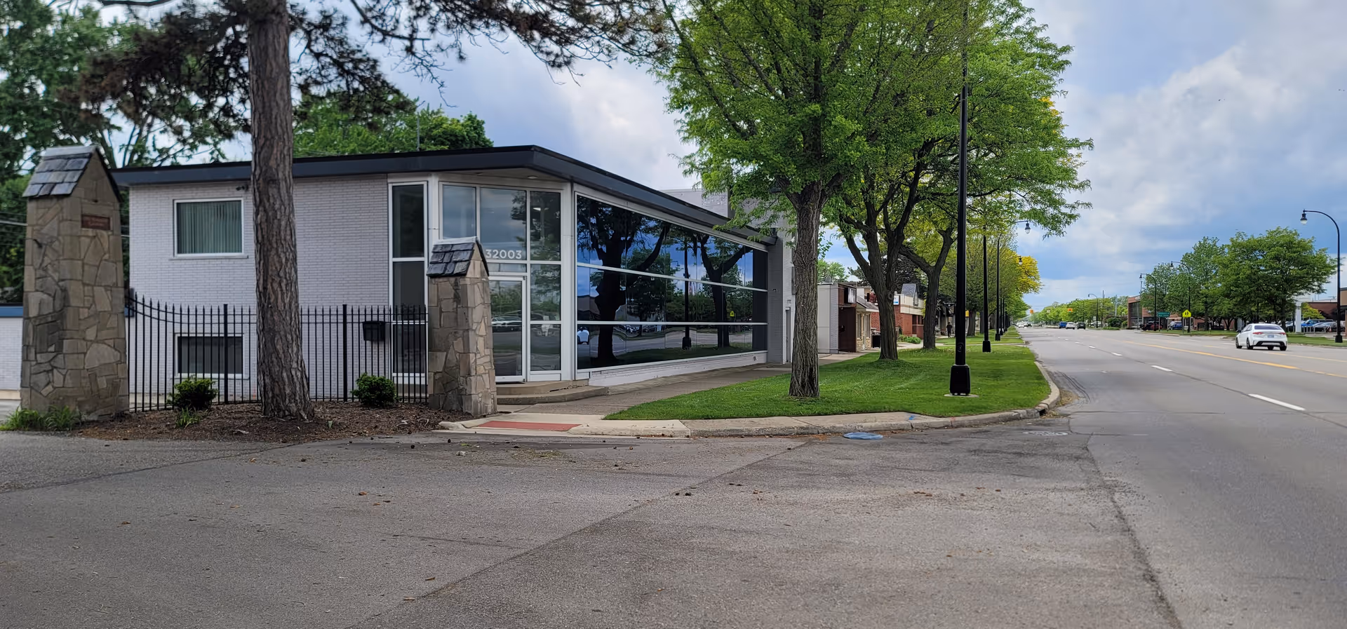 Exterior view of a modern single-story senior-care building with large glass windows.
