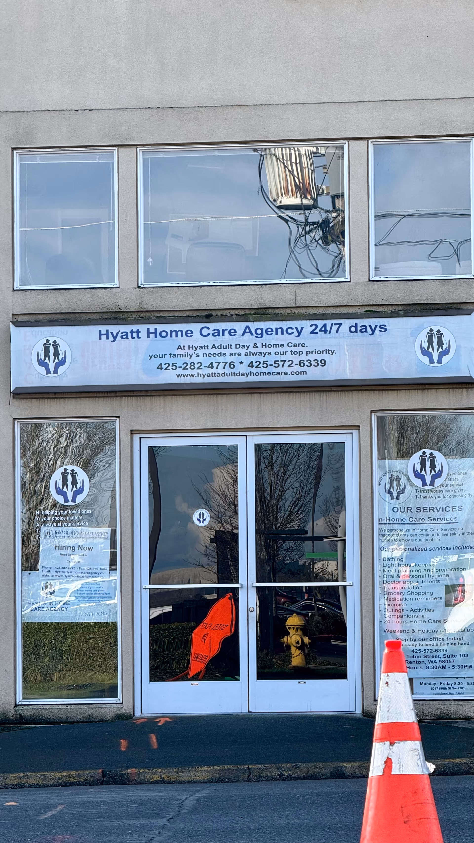 Front entrance of Hyatt Home Care Agency building with double doors and blue sign.
