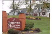 Front yard of a senior living facility with a brick sign reading Jefferson Hills