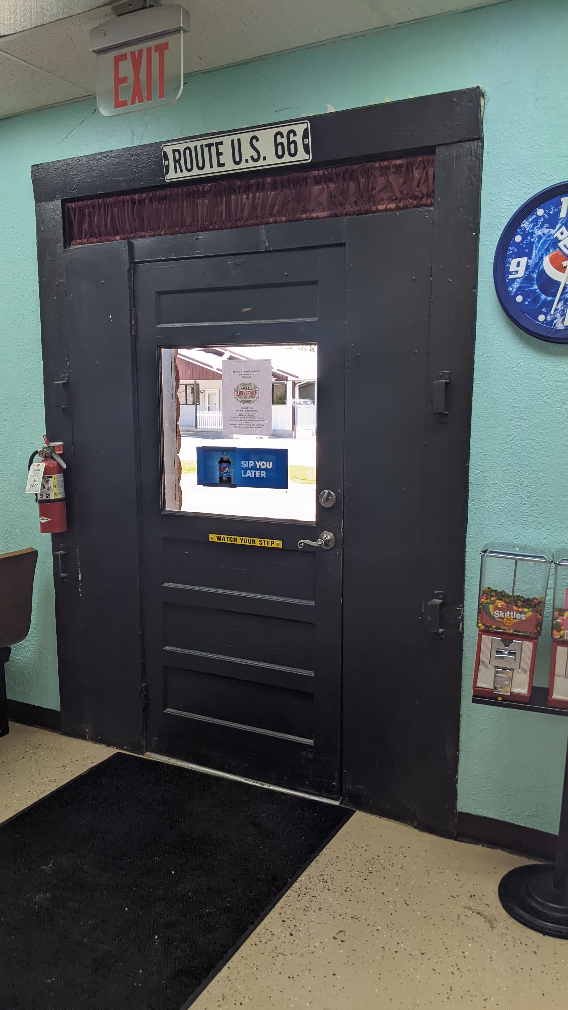 Interior hallway featuring a black door with Exit sign and Route 66 plaque.