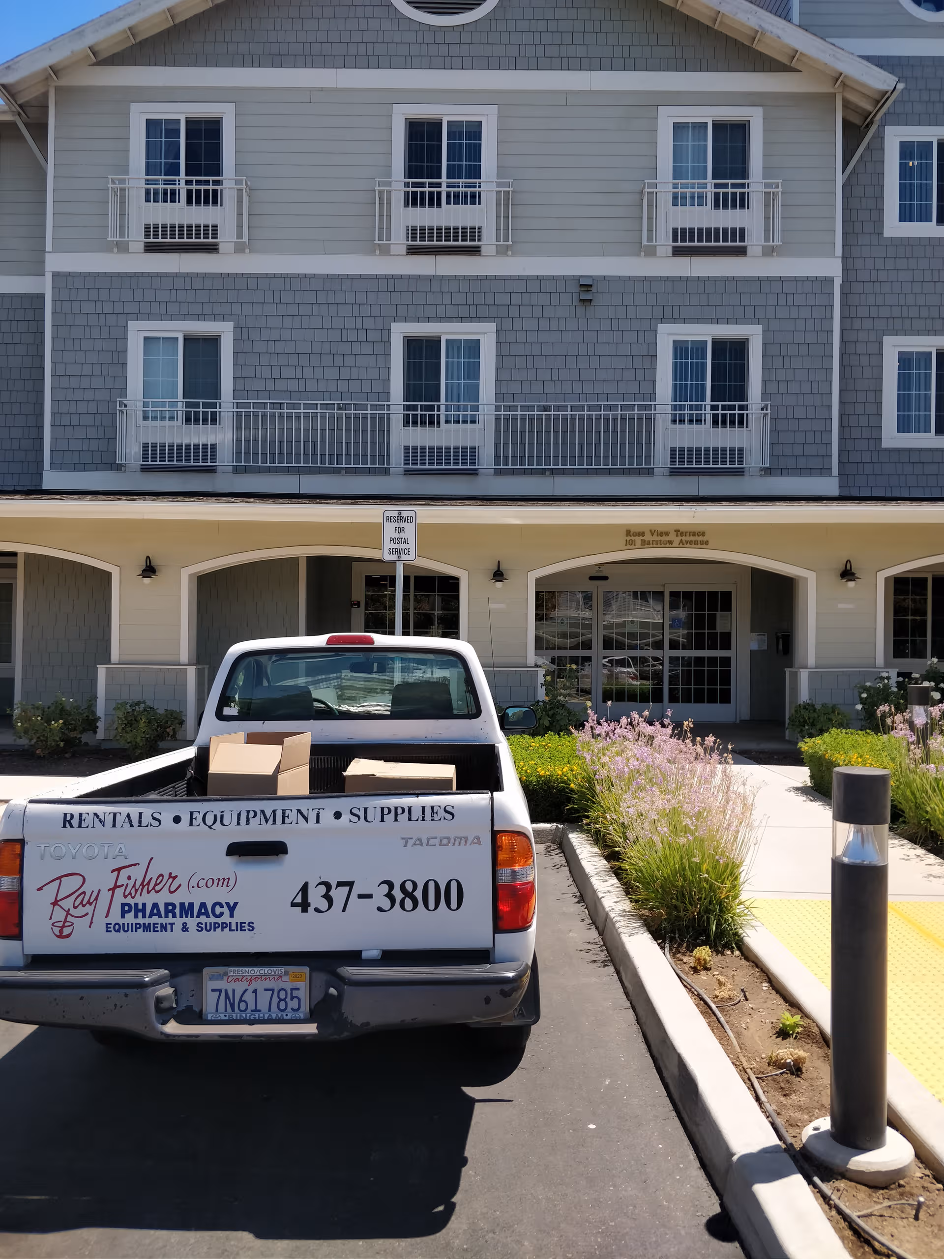 Rose View Terrace senior living building exterior with balconies and a pickup truck parked