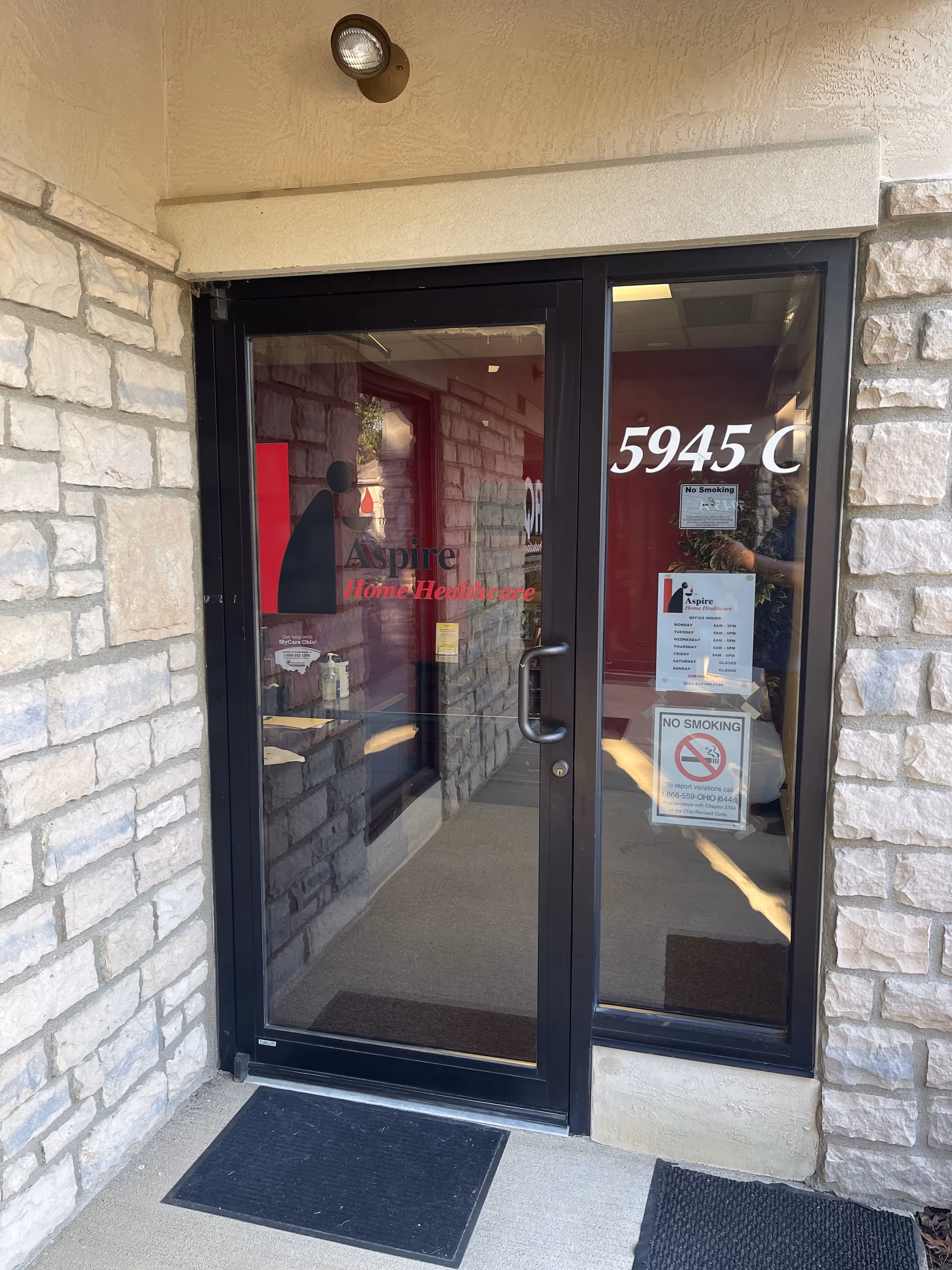 Glass entrance door with Aspire Home Healthcare signage on a stone exterior.