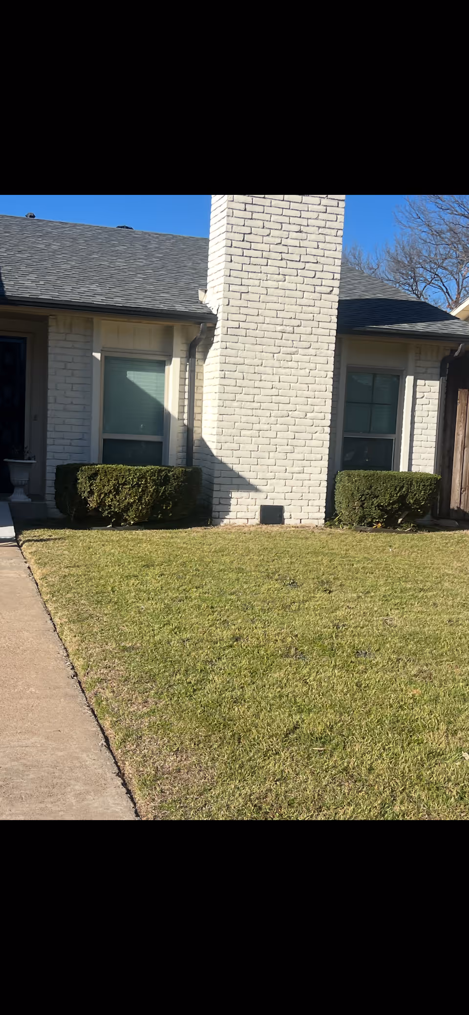 Front exterior of Divinity Residential care home with brick walls, windows, and a lawn.