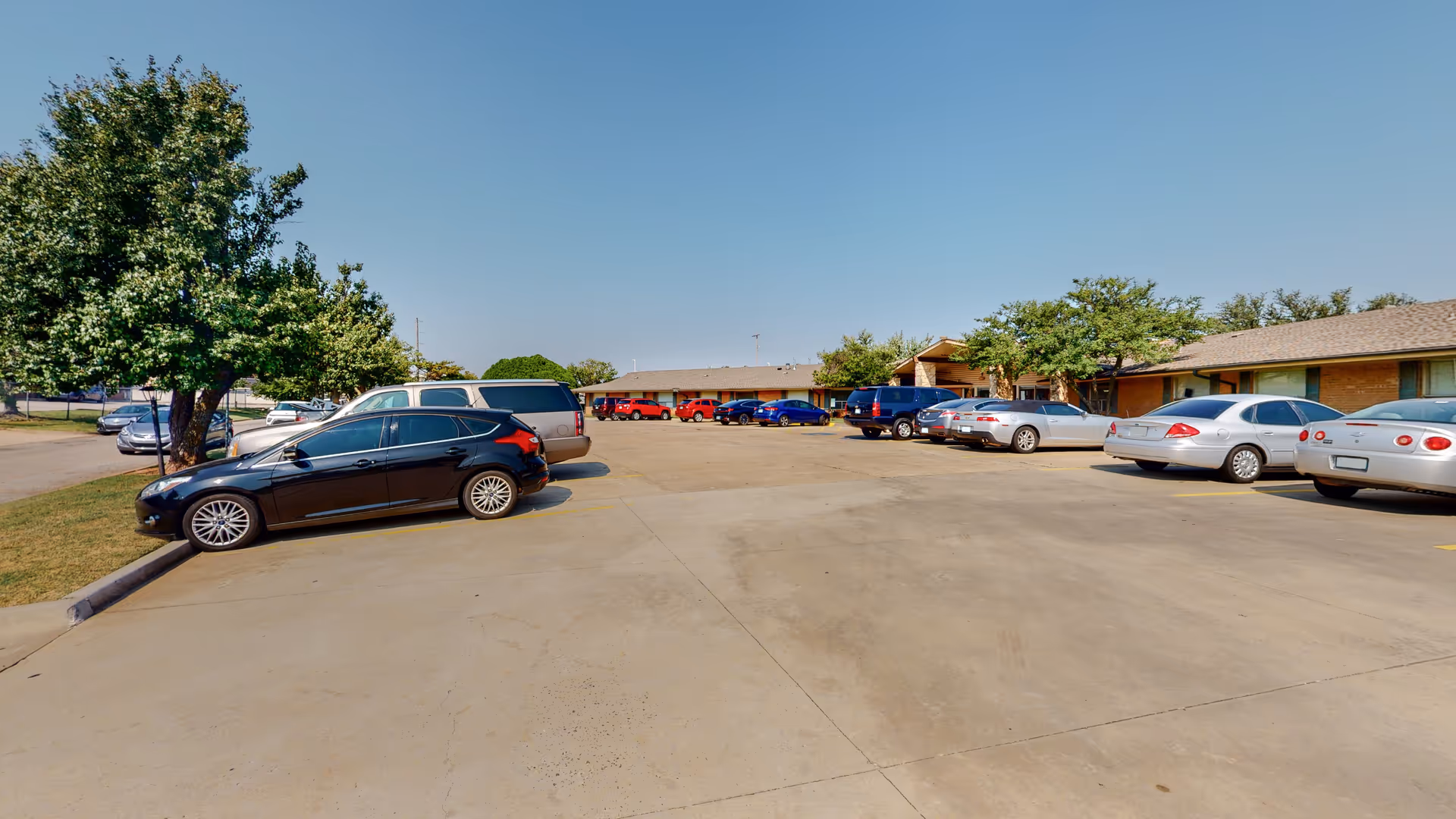 Exterior view of Northwest Nursing Center with a large parking lot and cars.