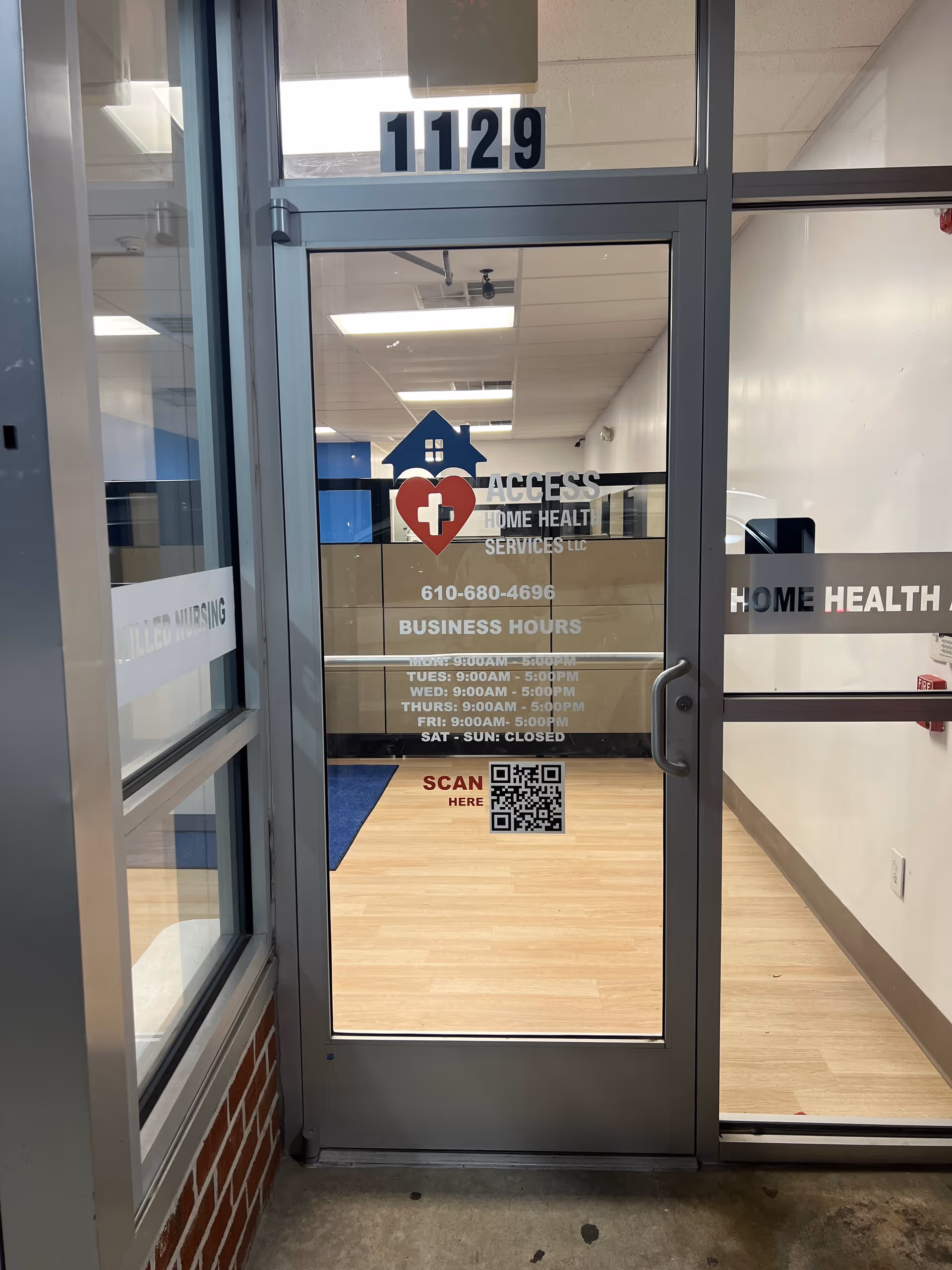 Glass entrance door with Access Home Health Services logo, number 1129, and QR code.