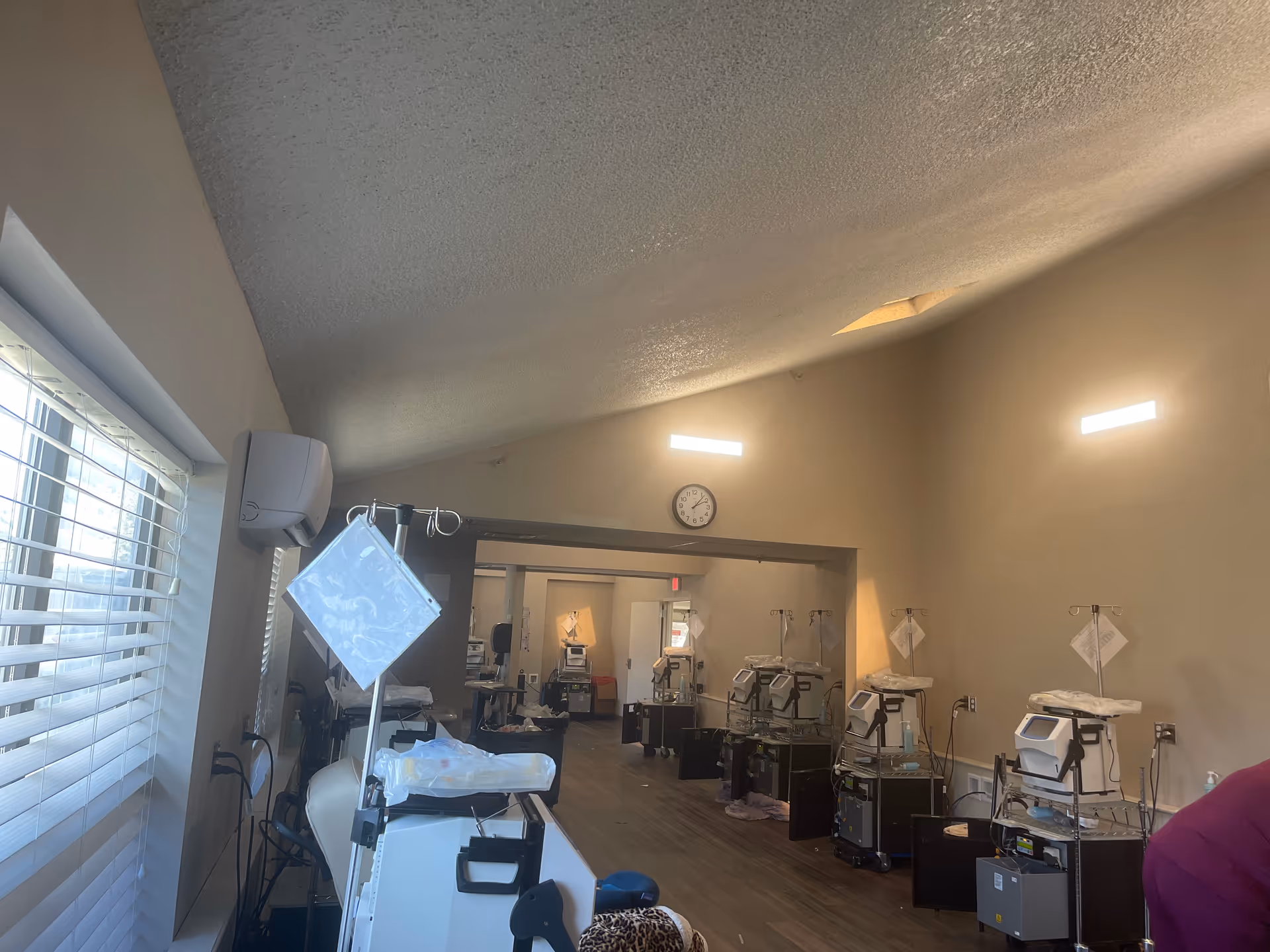Interior medical treatment room with a row of IV stands and equipment.