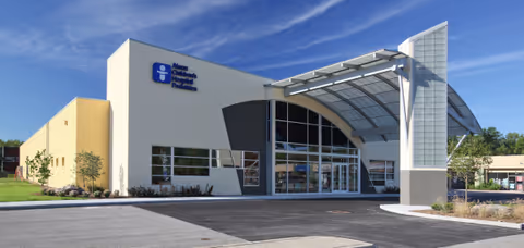 Modern medical center building with curved glass entry and a blue Akron Children's sign.