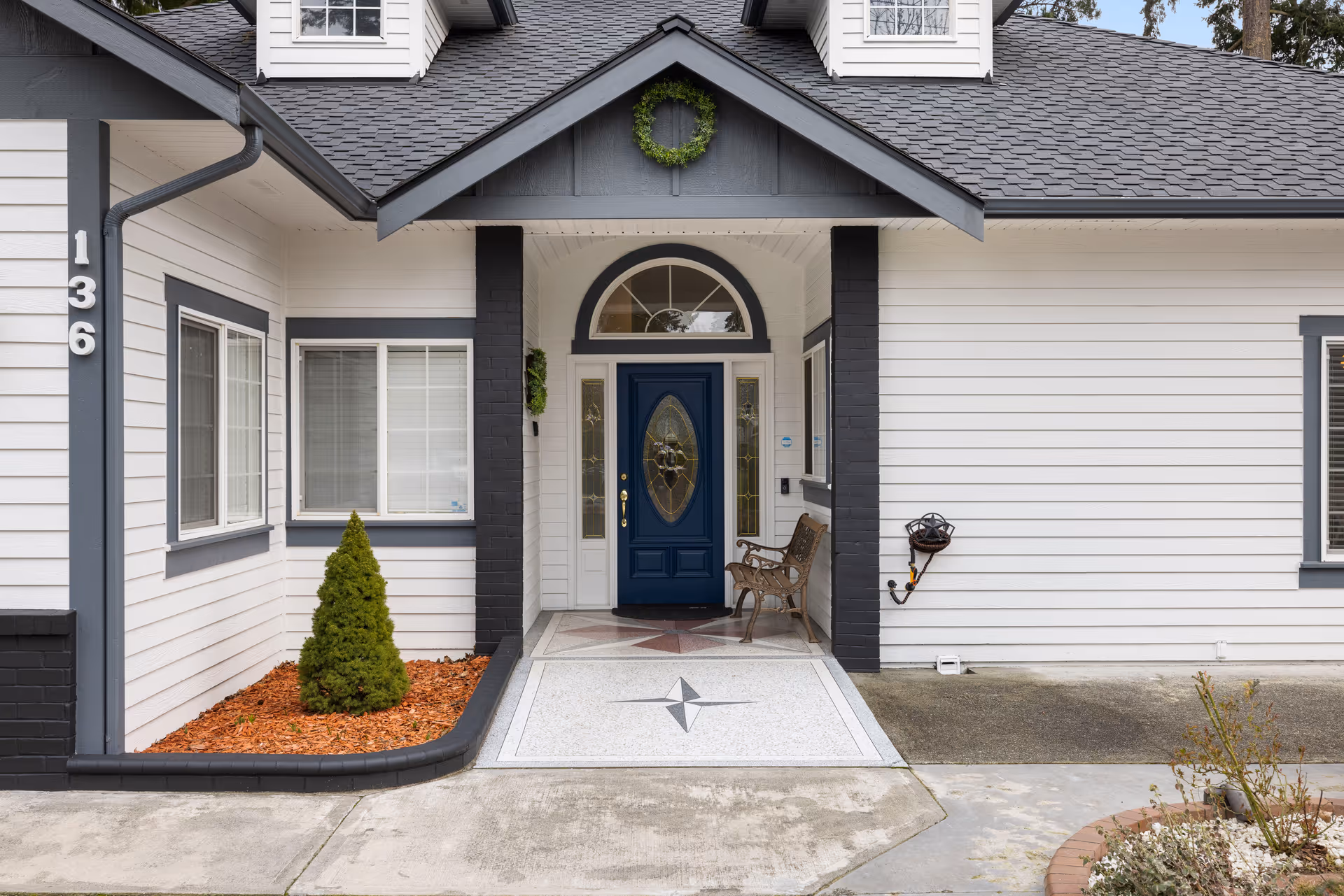 Front entrance of a light-colored building with a blue door and porch.