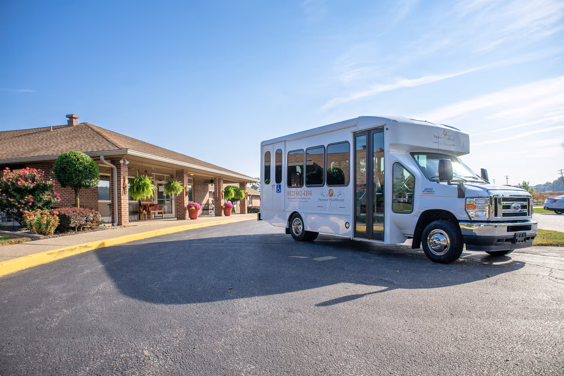 White shuttle bus parked in front of Premier Healthcare of New Harmony facility.