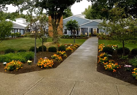 Paved walkway to Peregrine Senior Living at Crossgate with landscaped grounds.