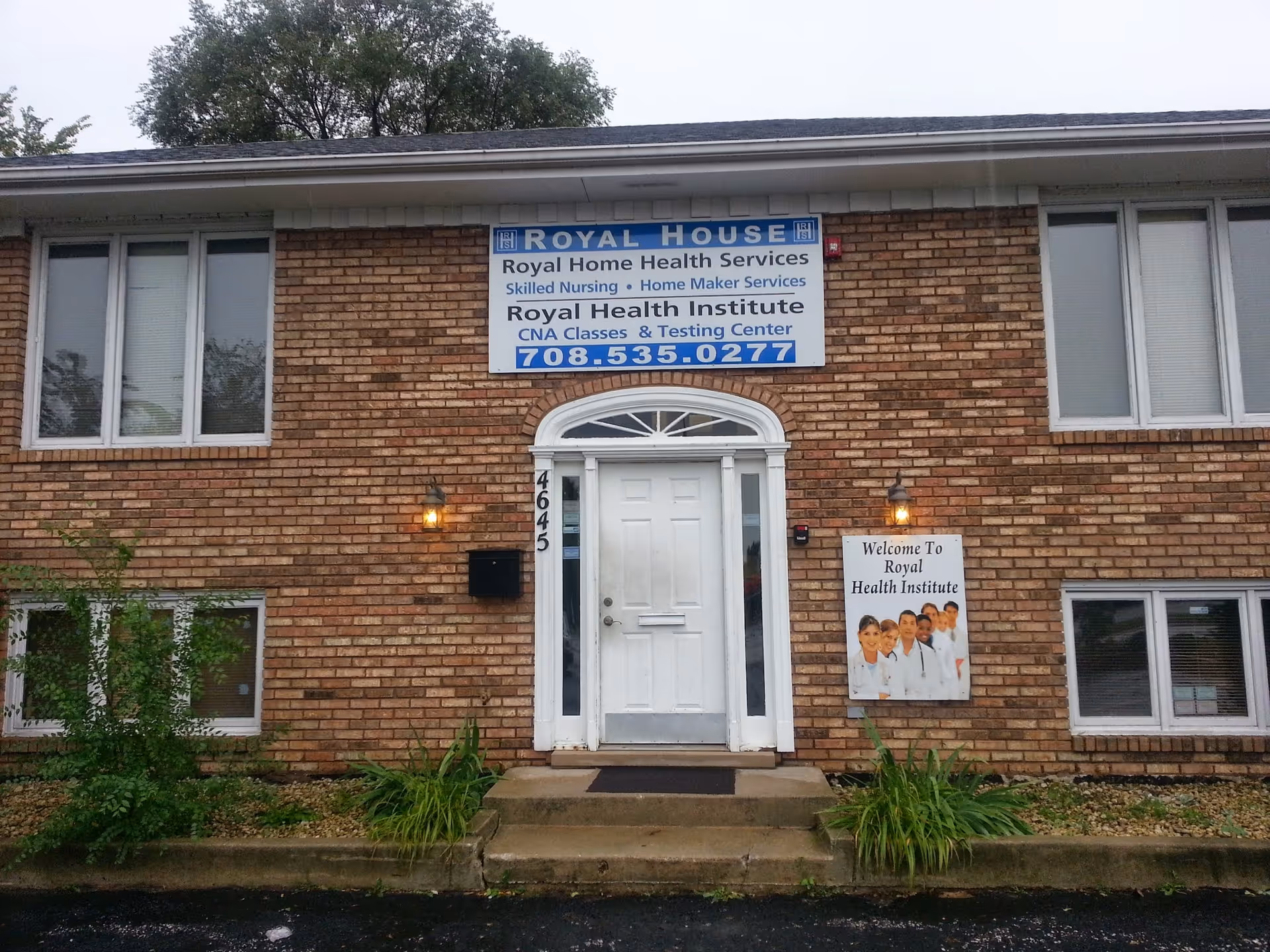 Brick building with a white front door and a large blue 'Royal House' sign above.