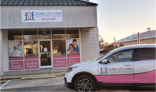 Exterior view of Home Life Care facility with a pink van parked in front.