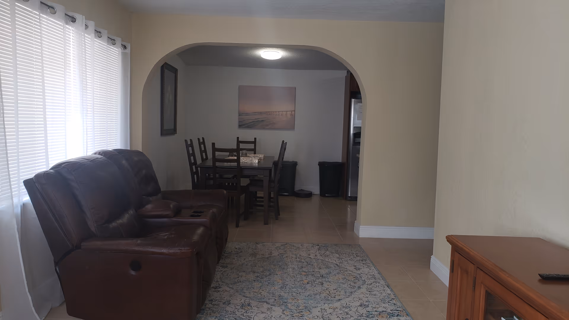 Cozy living room with brown leather recliners and an archway to a dining area.