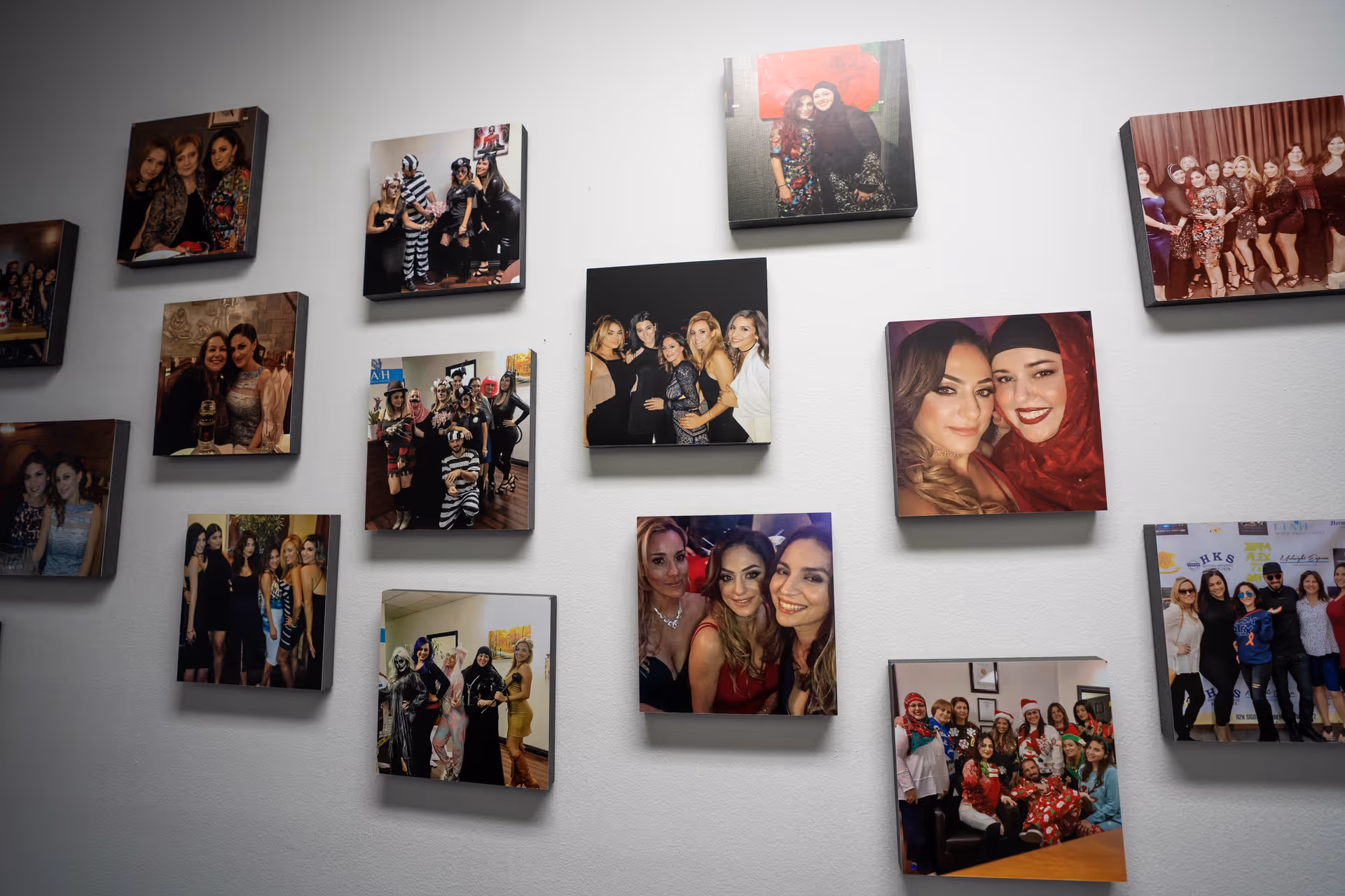 Interior wall displaying a grid of framed photos featuring various people.