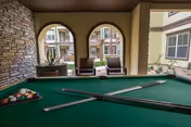 Pool table with cues in a covered indoor lounge at The View at Montecillo.