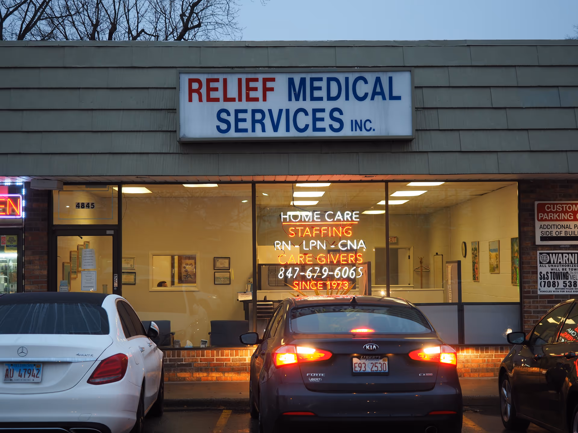 Exterior view of Relief Medical Services storefront with cars parked in front.