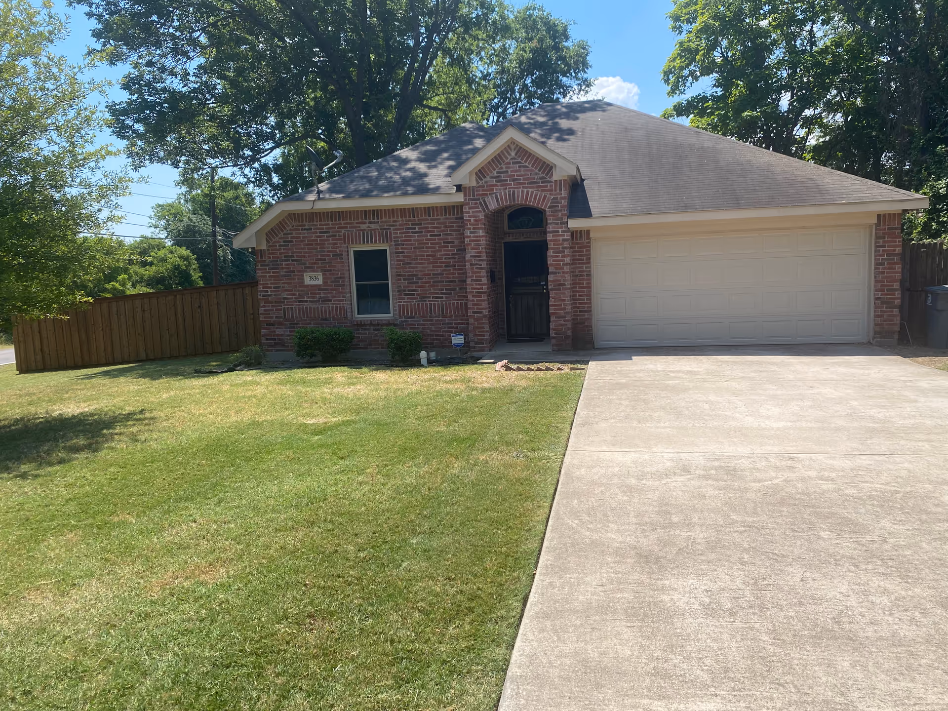 Brick house with a large two-car garage and a green front lawn.