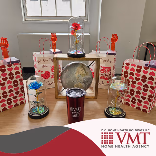 Interior table display with glass domes, a globe, heart-themed gift bags, and a window.
