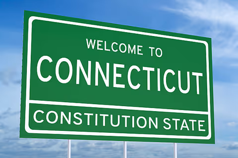Green Connecticut welcome sign against a blue sky.
