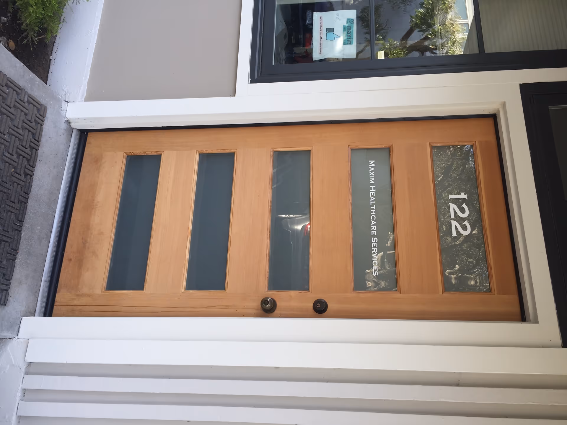 Exterior view of wooden front door with glass panels and 122 entrance