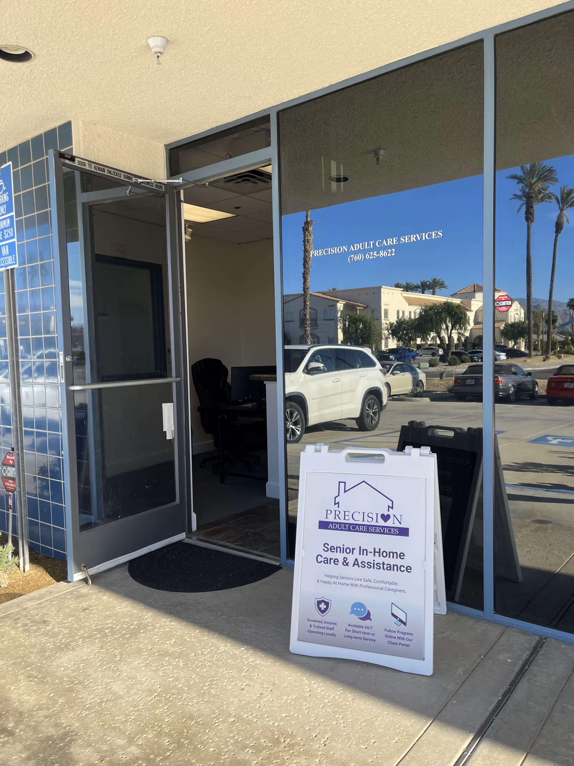 Front of Precision Adult Care Services building with glass entry and signboard.