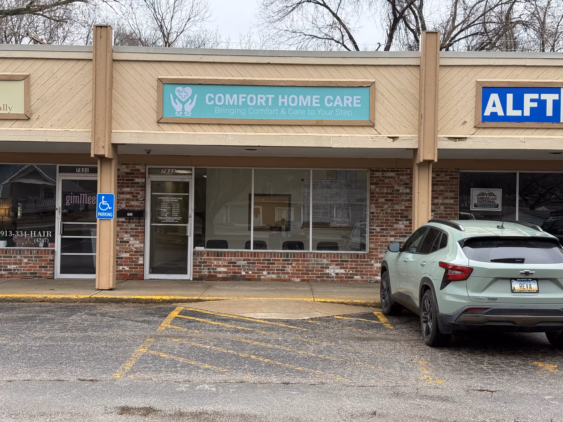 Front view of Comfort Home Care storefront with a parked car in a strip mall.