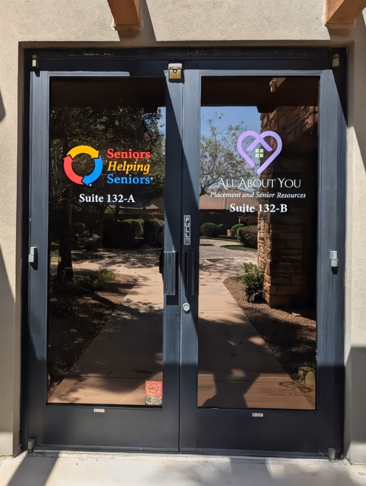 Entrance double glass doors with facility logos and Suite 132-A/B signage.