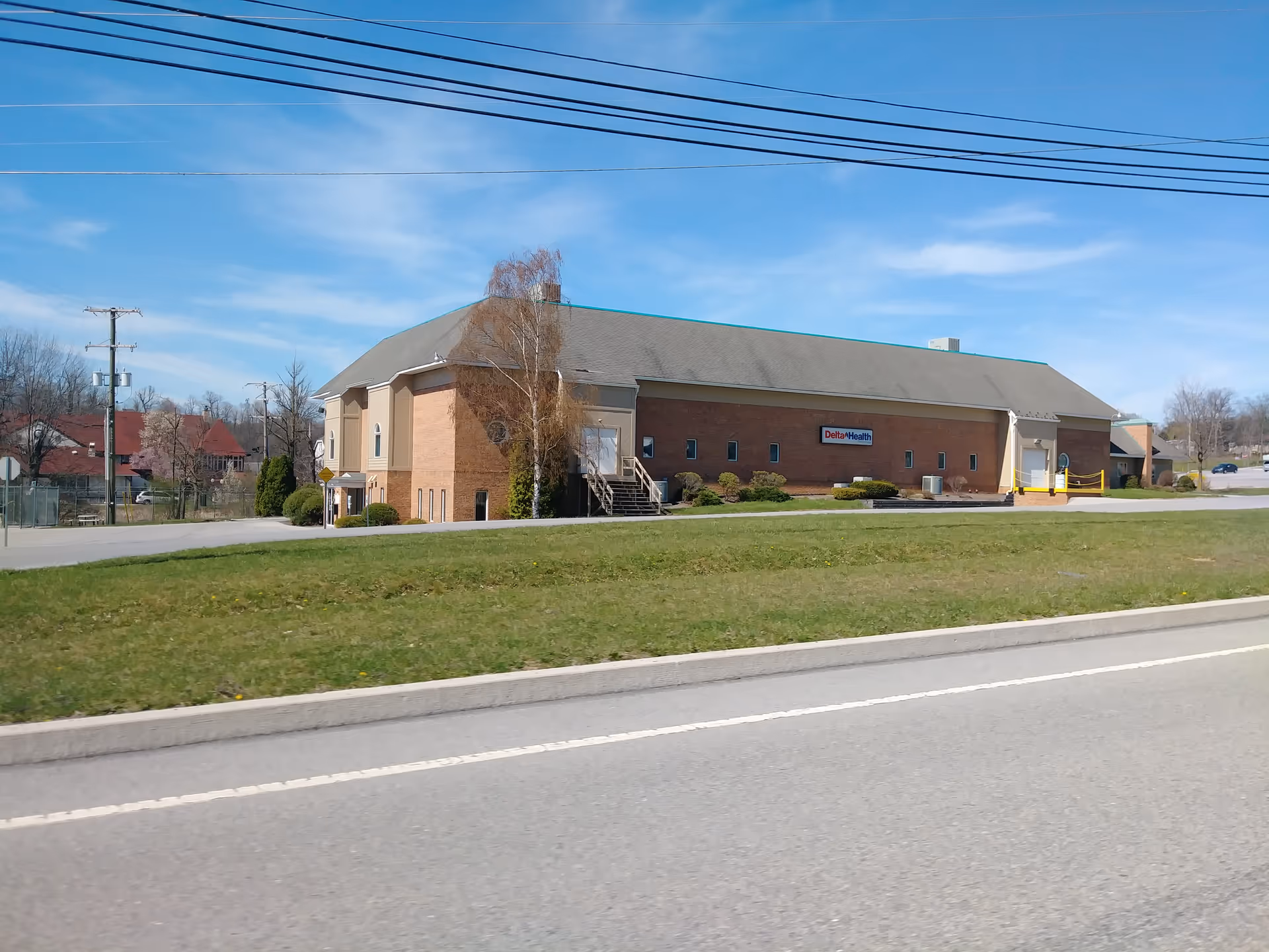 Exterior view of Delta Health Technologies LLC building along a road with landscaping.