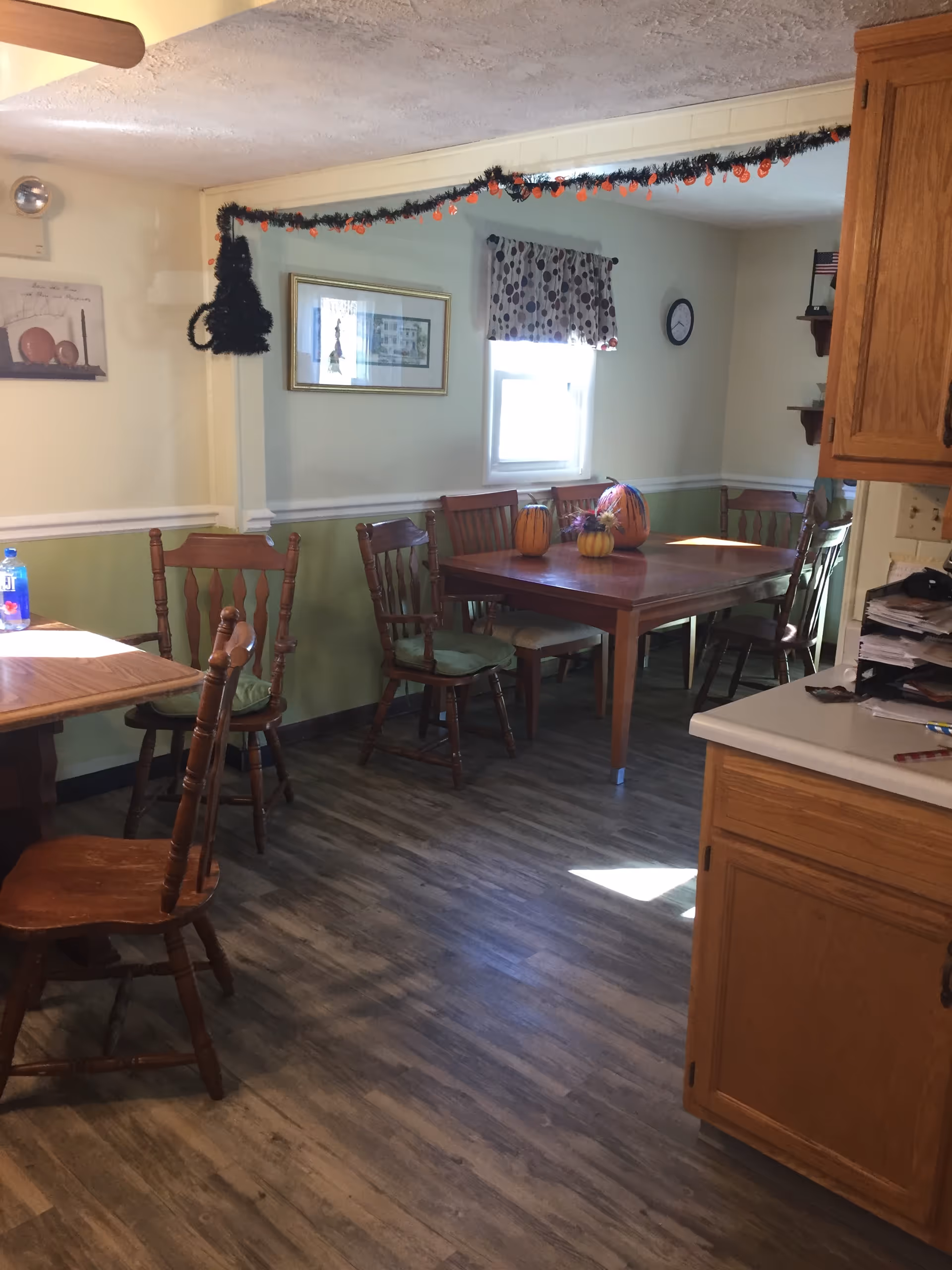 Cozy dining room in a senior living facility with pumpkins and garland.