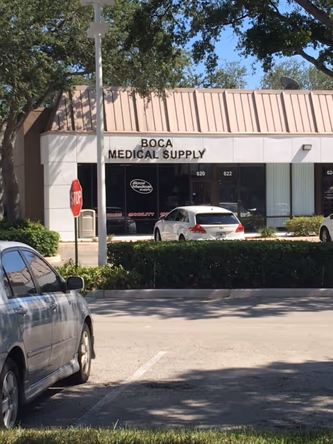 Exterior view of Boca Medical Supply storefront with parked cars and stop sign