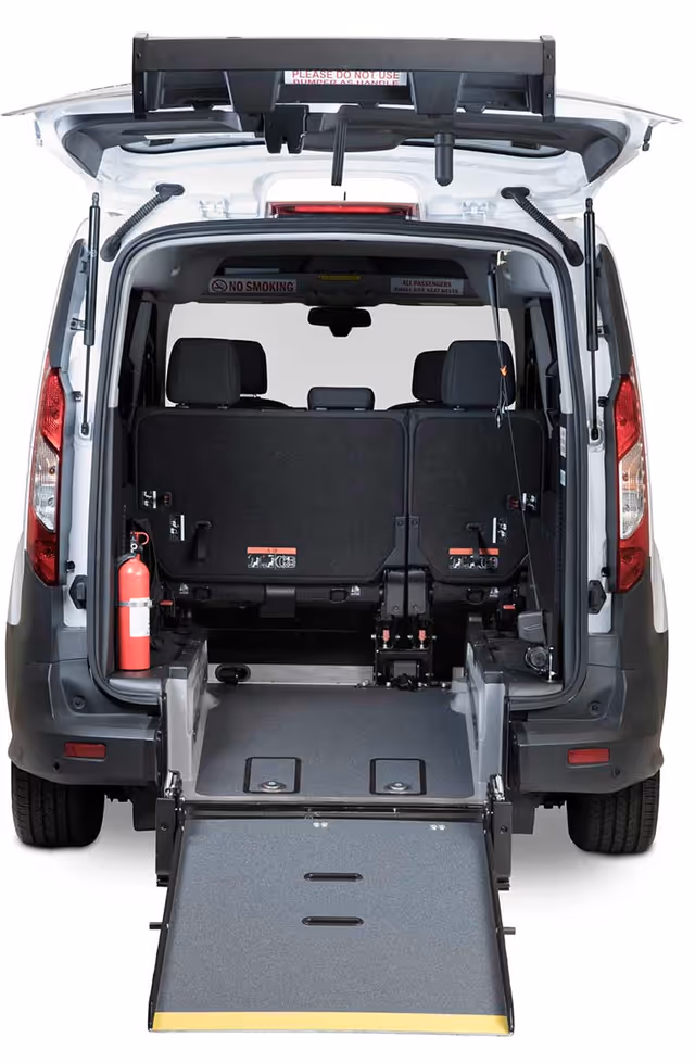 Rear view of an accessible van with extended ramp and wheelchair seating.