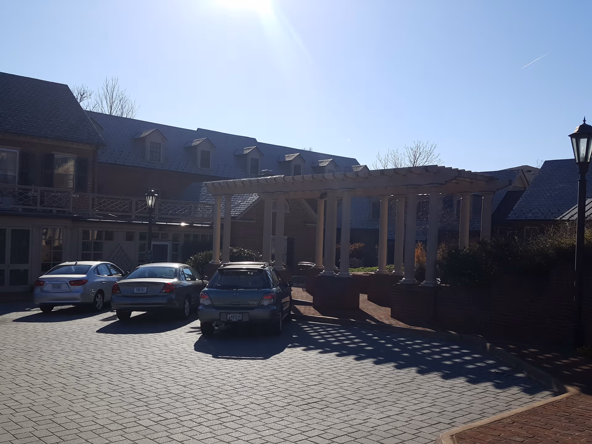 Exterior view of Martha Jefferson House with a covered walkway and parked cars.