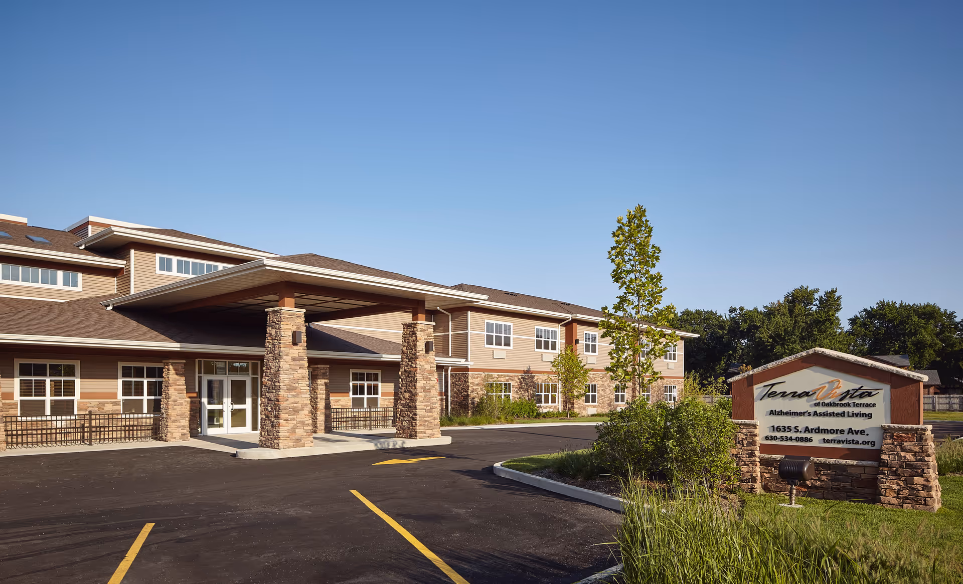 Exterior view of Terra Vista of Oakbrook Terrace entrance with parking and sign