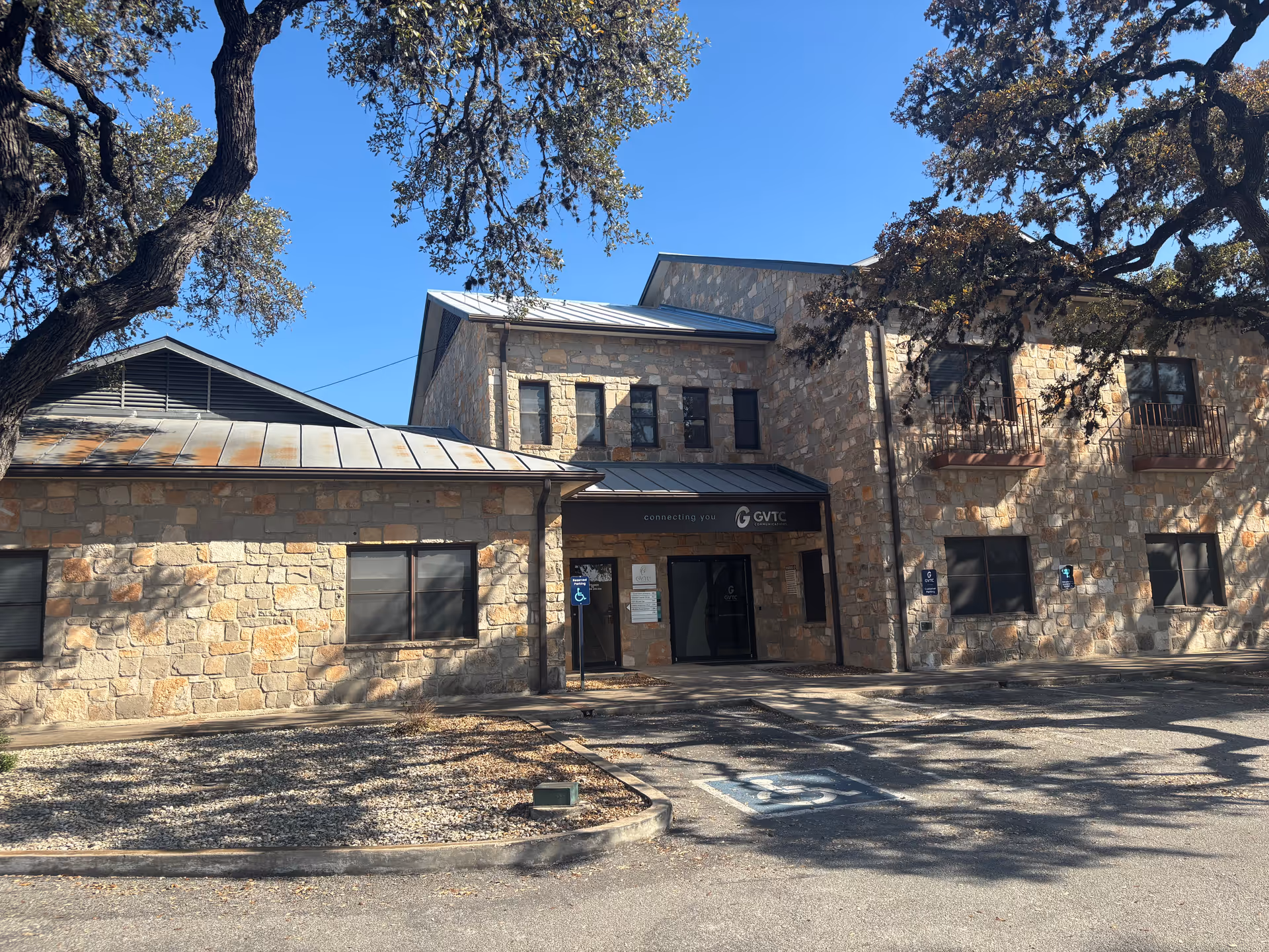 Stone-clad senior care facility exterior with entrance, parking lot, and wheelchair-accessible signage.